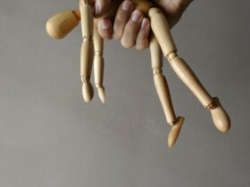 person holding brown wooden mannequin
