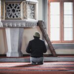 a man sitting on the floor in front of a clock