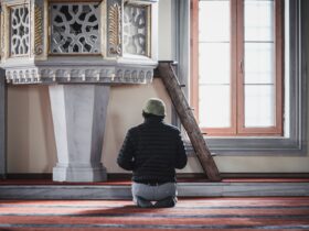 a man sitting on the floor in front of a clock