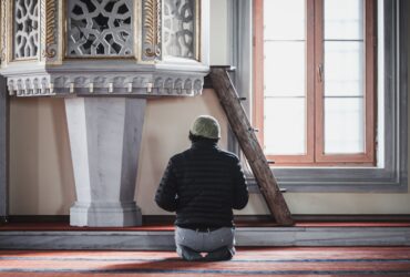 a man sitting on the floor in front of a clock