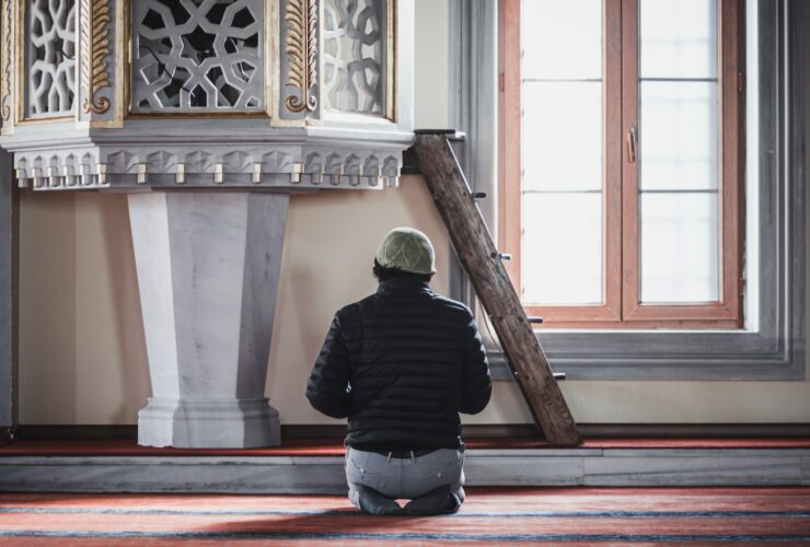 a man sitting on the floor in front of a clock