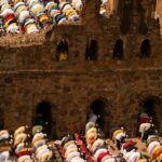 people in white blue and red shirts sitting on brown concrete stairs
