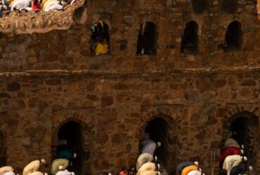 people in white blue and red shirts sitting on brown concrete stairs