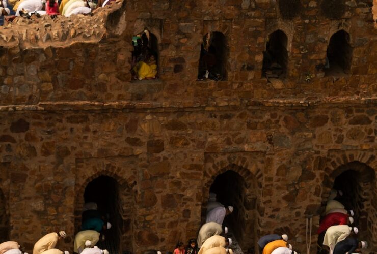 people in white blue and red shirts sitting on brown concrete stairs