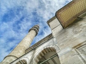 low angle photography of beige concrete building under blue sky during daytime