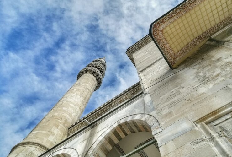 low angle photography of beige concrete building under blue sky during daytime