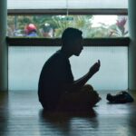 man in black shirt sitting on floor