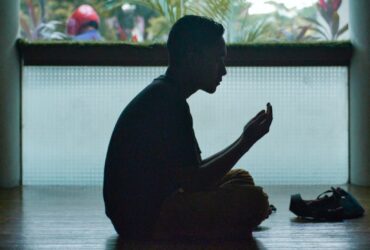 man in black shirt sitting on floor