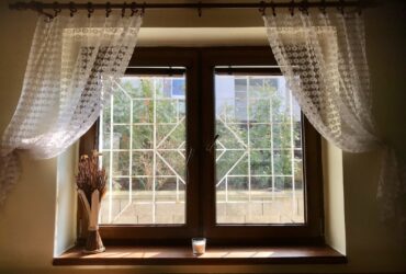 white floral window curtain on white wooden framed glass window