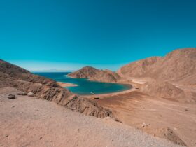 brown mountain near blue sea under blue sky during daytime