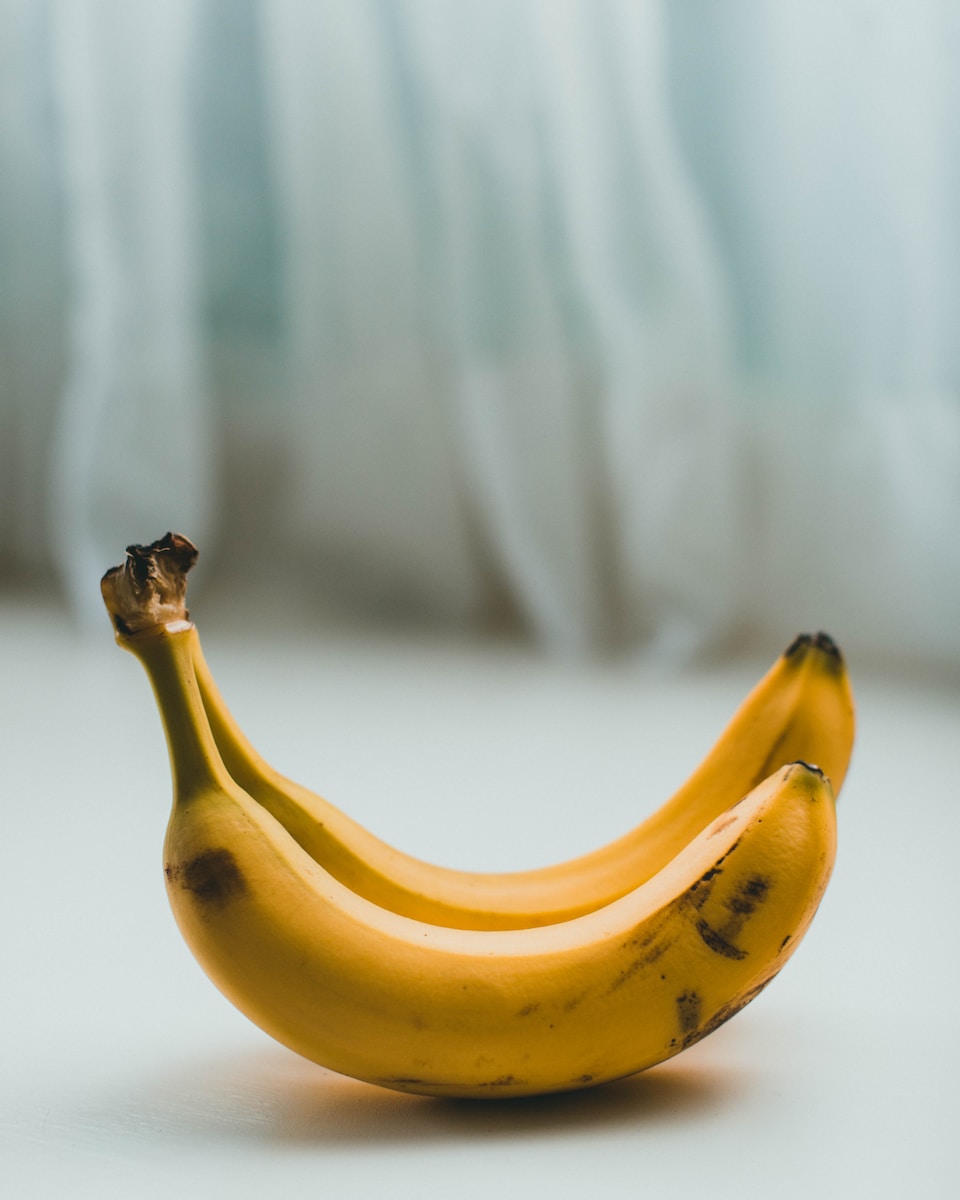 yellow banana fruit on white textile
