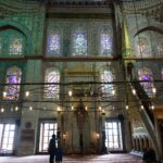 two people standing in a large building with stained glass windows