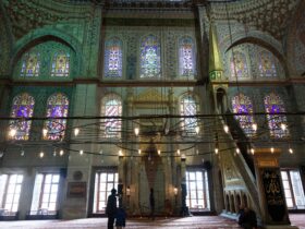 two people standing in a large building with stained glass windows