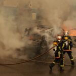 man in yellow and red suit holding black and yellow hose