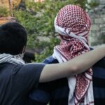 man in black shirt hugging woman in white and red hijab