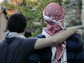 man in black shirt hugging woman in white and red hijab