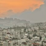 city with high rise buildings under orange sky