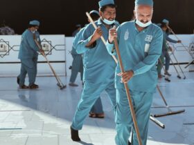 a group of men in blue uniforms with brooms