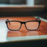 a pair of black glasses on a wooden surface