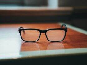 a pair of black glasses on a wooden surface