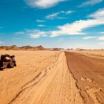black suv on brown sand under blue sky during daytime
