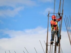 man wearing red hard hat hanged on brown rebar bar