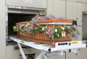 a wicker basket with flowers in it on a conveyor belt