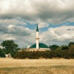 white and green concrete building under white clouds during daytime