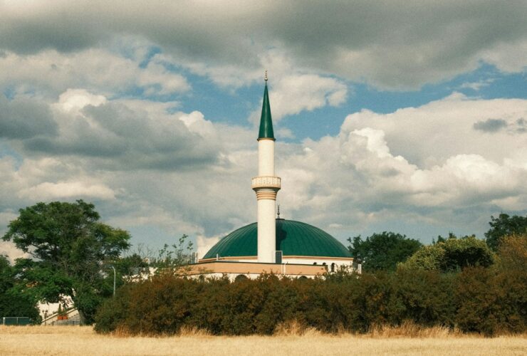 white and green concrete building under white clouds during daytime