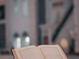 High angle of opened Koran book placed on stone stand in yard of ancient mosque