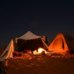 bonfire near tent under starry night