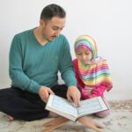 a man reading a book to a little girl