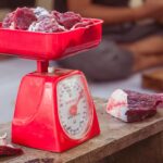 a red scale with meat on top of it