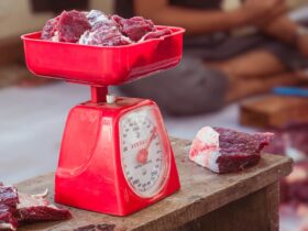 a red scale with meat on top of it