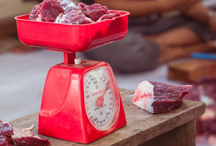 a red scale with meat on top of it