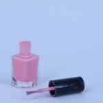 a bottle of pink nail polish next to a bottle of pink nail polish