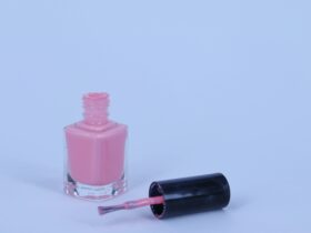 a bottle of pink nail polish next to a bottle of pink nail polish