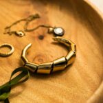 gold and green bracelet on brown textile