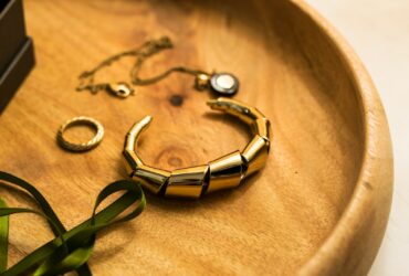 gold and green bracelet on brown textile