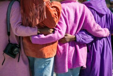 four person holding each others waist at daytime