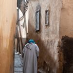 person wearing gray robe holding stick during daytime
