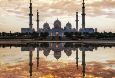 white and gray mosque in front of body of water