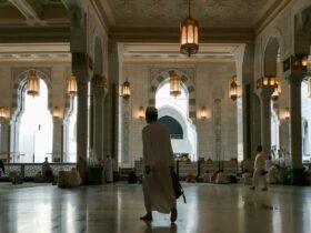 a man in a white robe is walking through a building