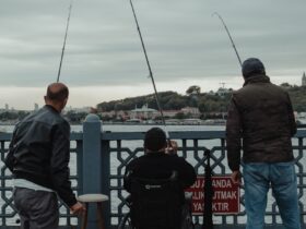 man in black jacket and blue denim jeans standing beside man in black jacket