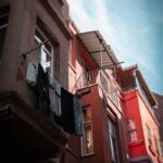 A red building with a balcony and clothes hanging out of it