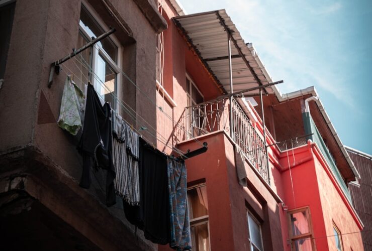 A red building with a balcony and clothes hanging out of it