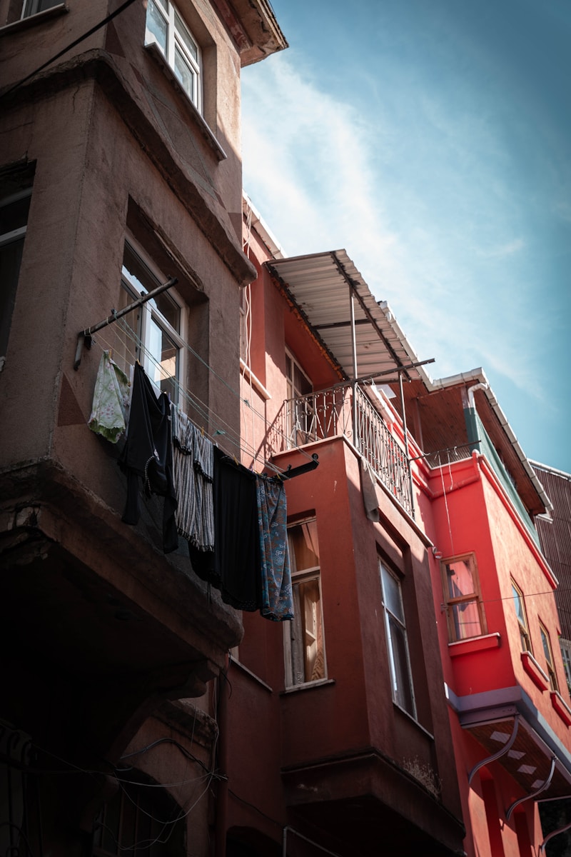 A red building with a balcony and clothes hanging out of it