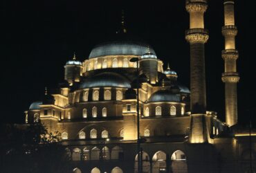 A large building lit up at night with lights on it