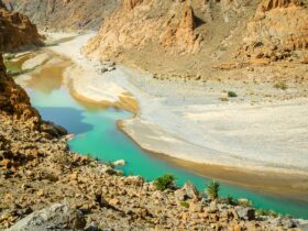 brown rocky mountain near blue lake during daytime