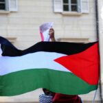 a person holding a flag in front of a building